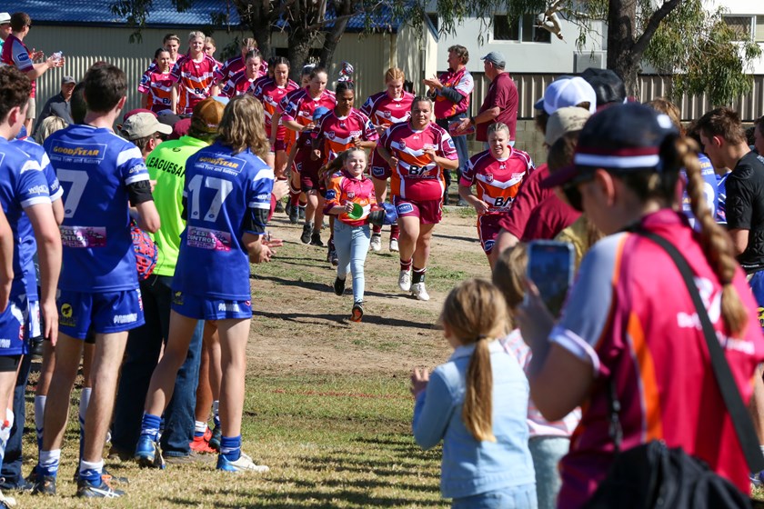 Hayley helping to lead QLD Outback out onto the field. Photo: Jorja Brinums/QRL