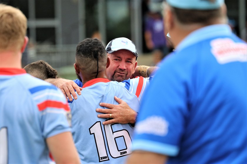 Col Speed embraces one of his players after coaching Toowoomba to XXXX 47th Battalion glory in 2023.